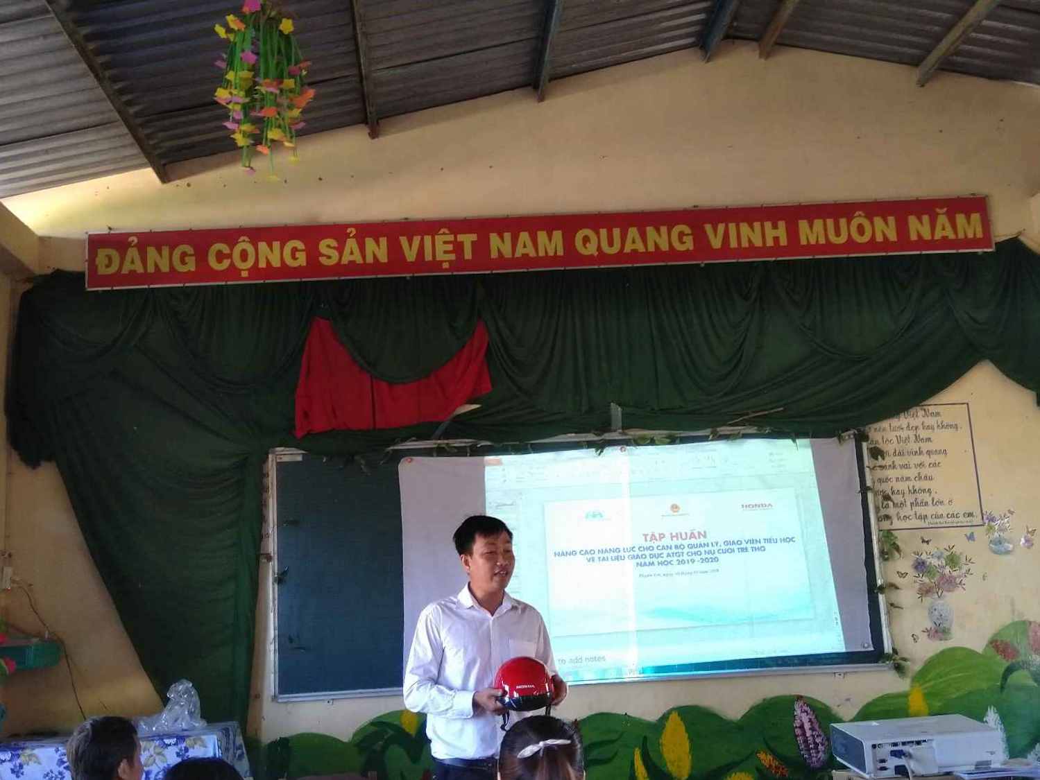 Thầy Trần Hữu Phước hướng dẫn đội nón bảo hiểm đúng cách khi tham gia giao thông.